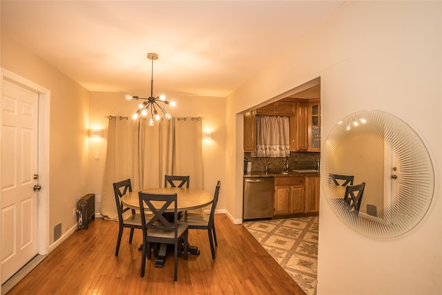 dining area featuring light wood finished floors, baseboards, and a chandelier