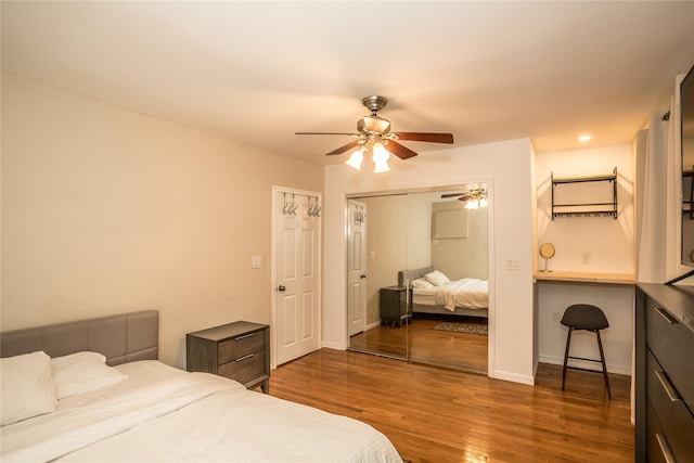 bedroom featuring ceiling fan, a closet, wood finished floors, and baseboards