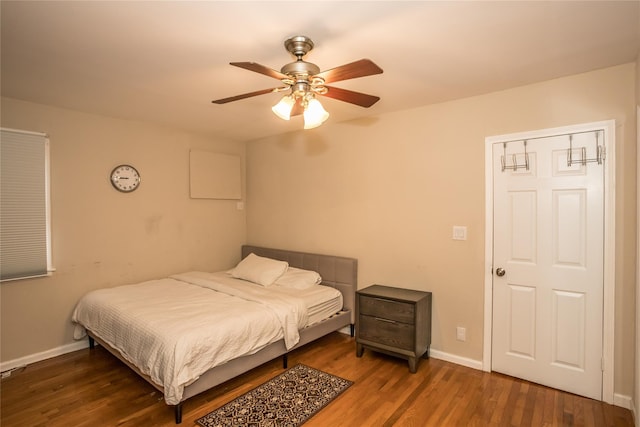 bedroom featuring ceiling fan, baseboards, and wood finished floors