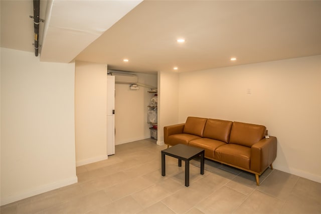 living area featuring recessed lighting, a wall unit AC, and baseboards