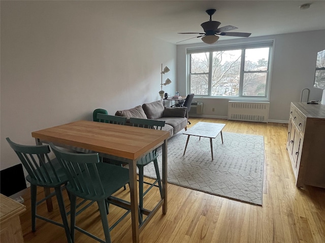 dining area featuring radiator, ceiling fan, and light wood-type flooring