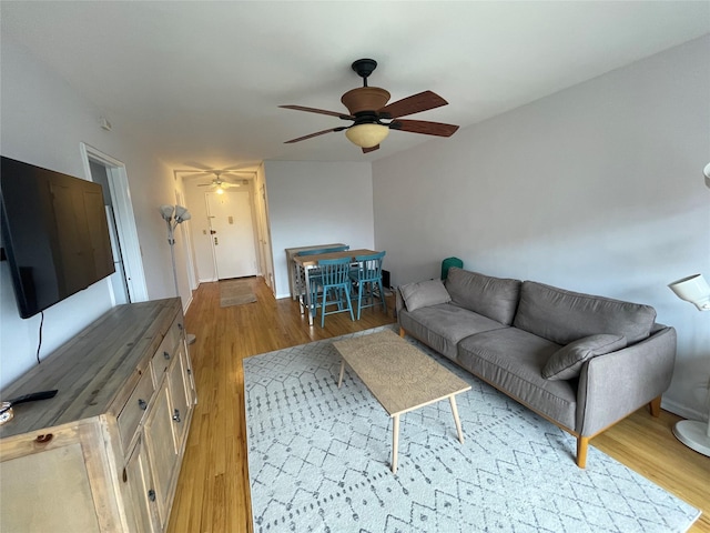 living room featuring light hardwood / wood-style flooring and ceiling fan