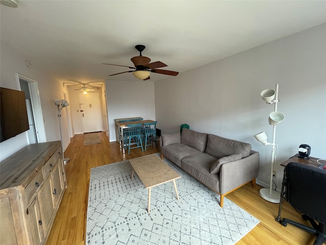 living room with ceiling fan and light hardwood / wood-style flooring