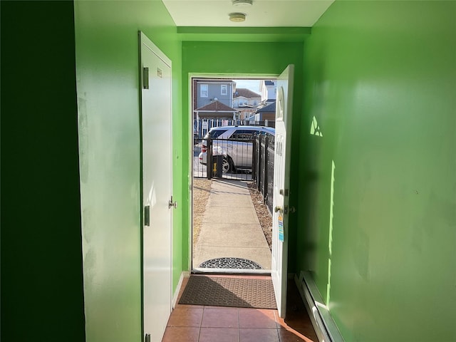 corridor featuring a baseboard heating unit and light tile patterned flooring