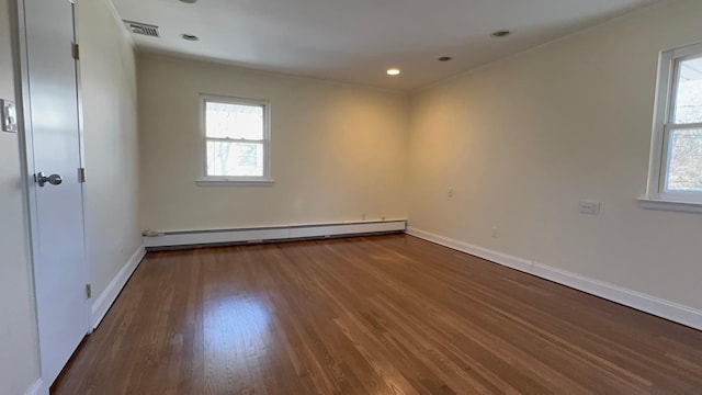 empty room with a baseboard radiator, plenty of natural light, and dark hardwood / wood-style flooring