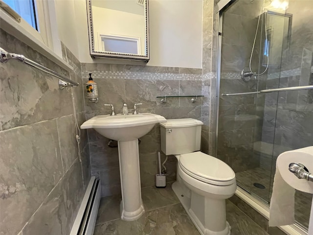 bathroom featuring tile walls, a shower with door, toilet, and baseboard heating