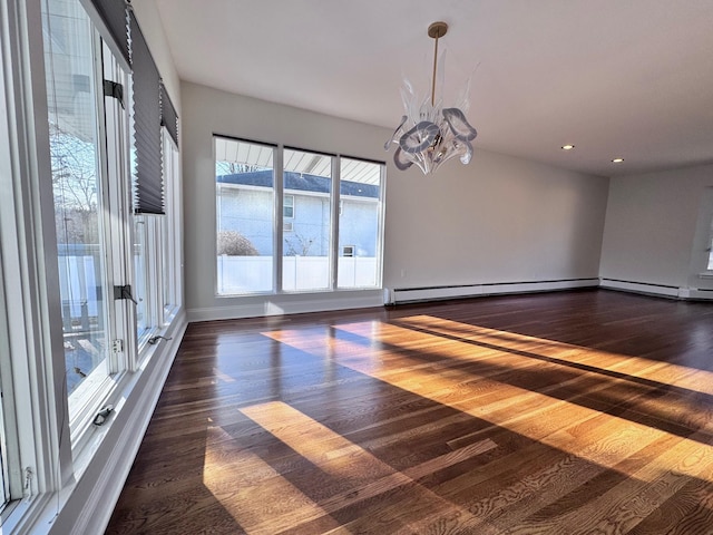 unfurnished room with a baseboard heating unit, dark hardwood / wood-style floors, and an inviting chandelier