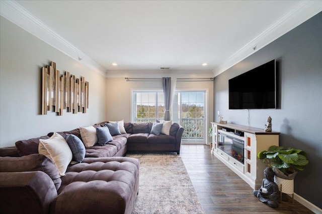 living area with baseboards, recessed lighting, wood finished floors, and crown molding