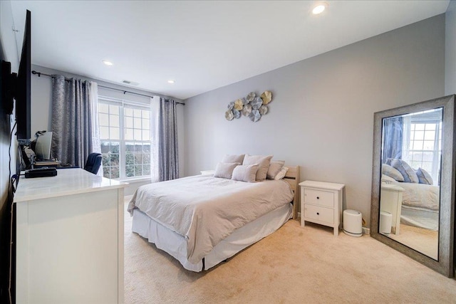 bedroom featuring light carpet, visible vents, and recessed lighting