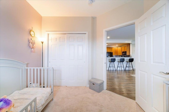 bedroom with a closet, fridge, and carpet flooring