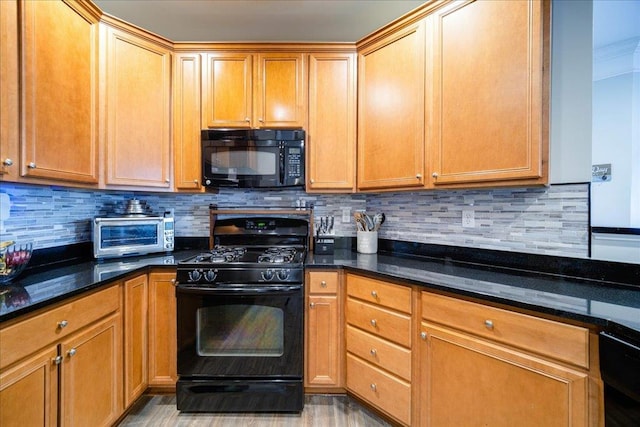 kitchen with black appliances, a toaster, dark stone countertops, and decorative backsplash