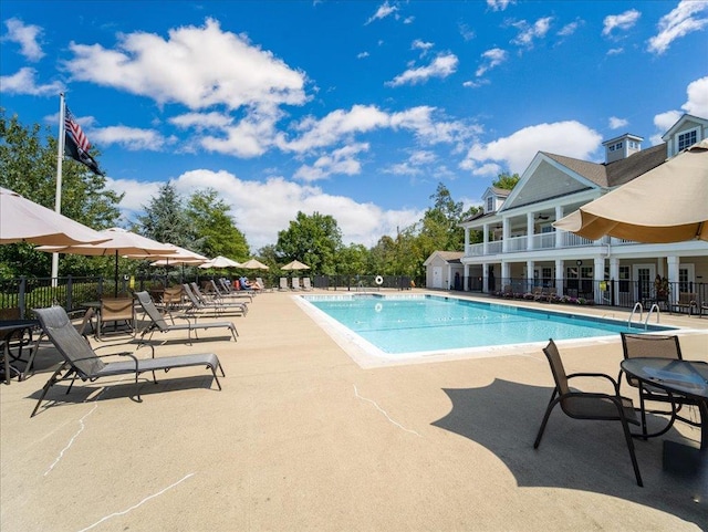 community pool with fence and a patio