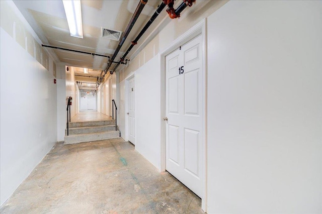 corridor with unfinished concrete floors and visible vents