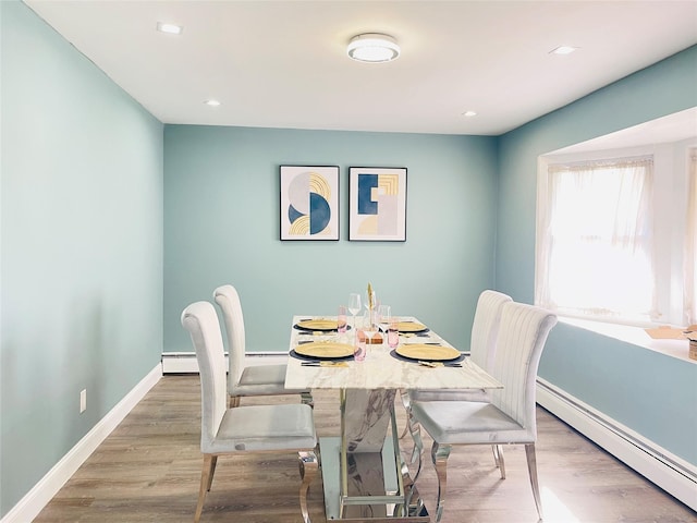 dining area featuring a baseboard heating unit and light wood-type flooring