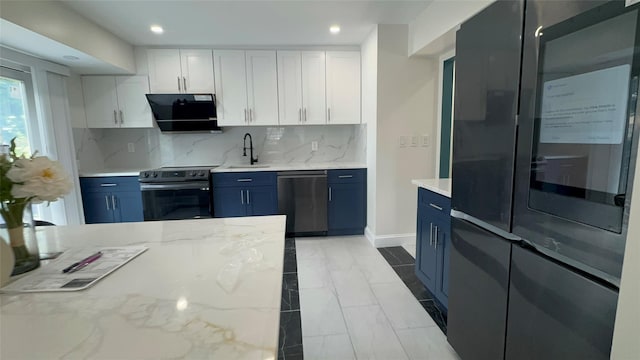 kitchen featuring blue cabinets, exhaust hood, white cabinets, and appliances with stainless steel finishes