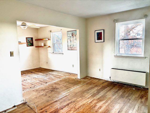 empty room with hardwood / wood-style flooring and radiator