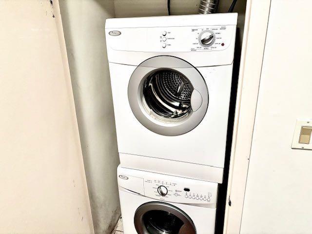 washroom featuring stacked washing maching and dryer