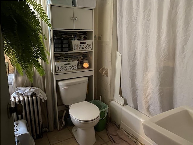 bathroom featuring radiator, tile patterned floors, toilet, and shower / bath combo with shower curtain