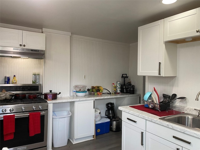 kitchen featuring white cabinetry, dark wood-type flooring, stainless steel gas range, and sink