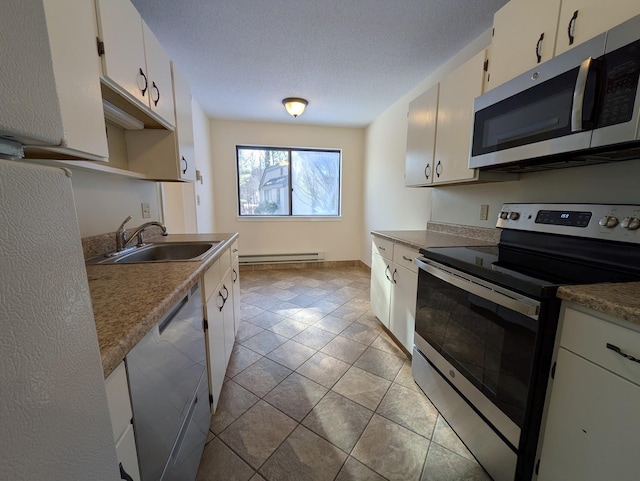 kitchen with sink, baseboard heating, white cabinetry, appliances with stainless steel finishes, and a textured ceiling