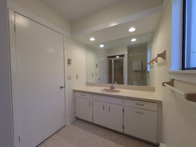 bathroom with vanity, a shower with shower door, tile patterned floors, and toilet