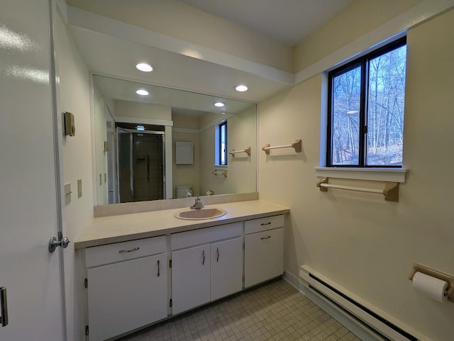 bathroom featuring baseboard heating, vanity, toilet, and tile patterned flooring