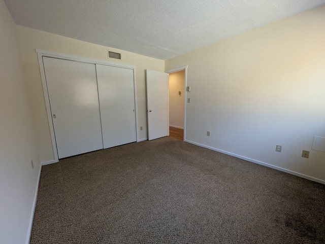 unfurnished bedroom with a closet, a textured ceiling, and carpet