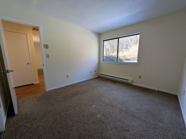 carpeted empty room featuring baseboard heating and a textured ceiling