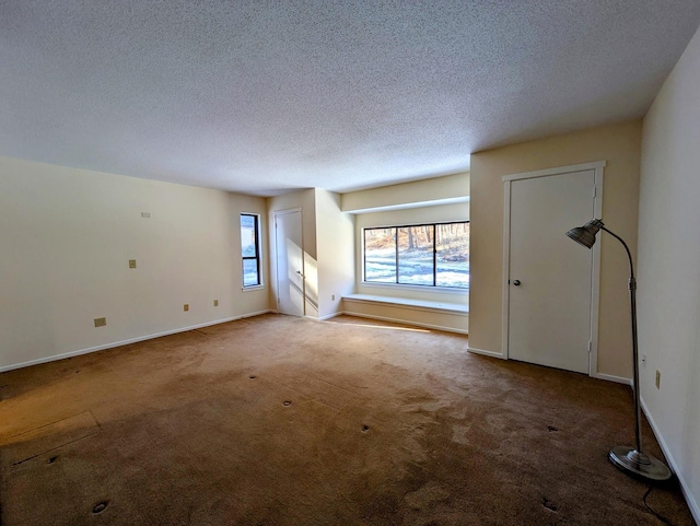 carpeted empty room with a textured ceiling