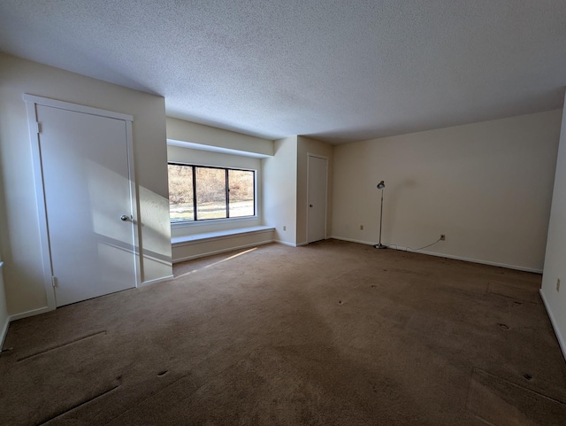 unfurnished room with carpet flooring and a textured ceiling