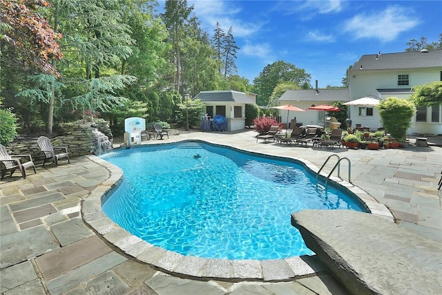 view of pool with a fenced in pool, a patio area, and an outdoor structure