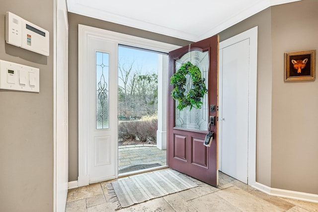 entryway featuring baseboards, ornamental molding, and stone tile floors