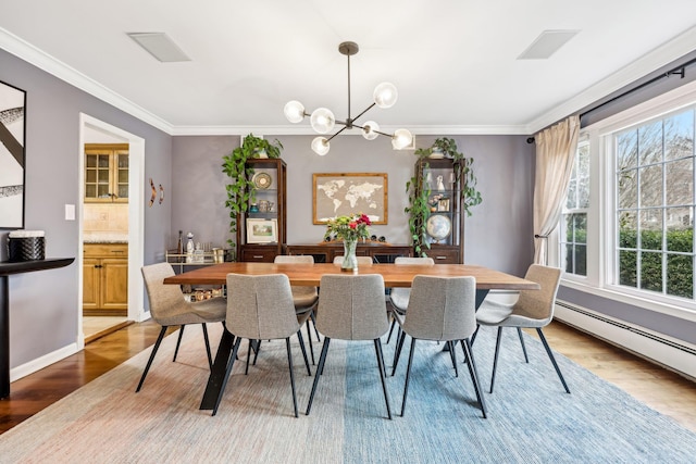 dining space featuring a chandelier, crown molding, and wood finished floors