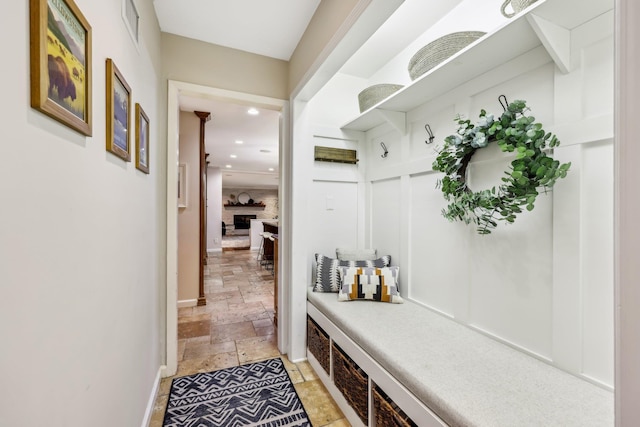 mudroom with stone tile floors, visible vents, baseboards, a fireplace, and recessed lighting