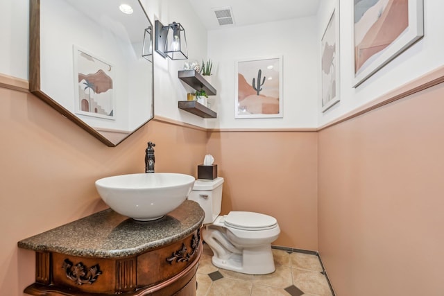 bathroom with visible vents, vanity, toilet, and tile patterned floors