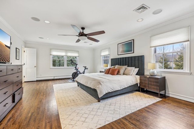 bedroom featuring visible vents, baseboards, ornamental molding, baseboard heating, and dark wood finished floors