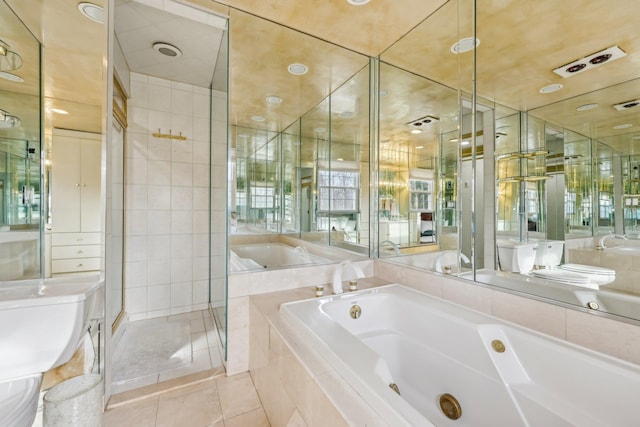 bathroom featuring a stall shower, tile patterned flooring, a garden tub, and toilet