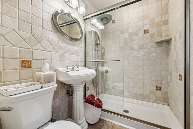 full bath with a shower stall, toilet, and tile walls