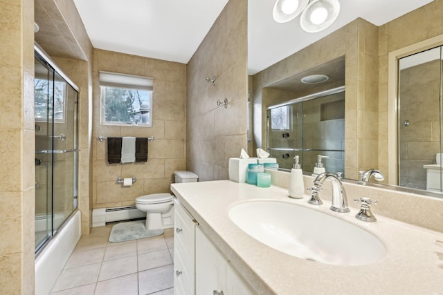 bathroom featuring shower / bath combination with glass door, tile walls, toilet, a baseboard heating unit, and tile patterned floors