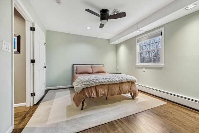 bedroom featuring baseboards, baseboard heating, wood finished floors, and recessed lighting