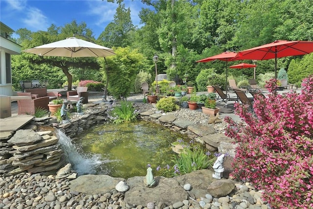 exterior space featuring a garden pond and a patio area