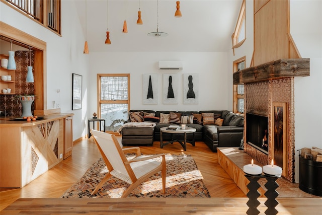 living room featuring a wall mounted air conditioner, light hardwood / wood-style floors, and a high ceiling