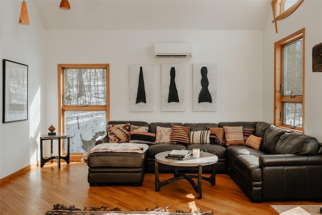 living room featuring a wall mounted air conditioner and light hardwood / wood-style floors