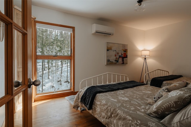 bedroom featuring wood-type flooring and a wall unit AC