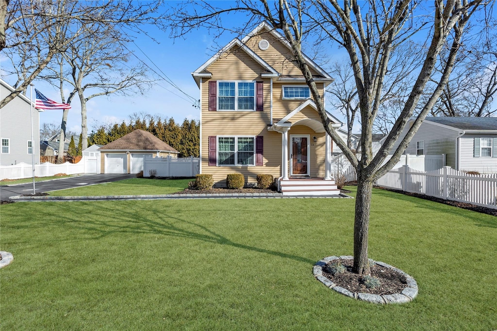 view of front of property featuring a garage, an outbuilding, and a front lawn