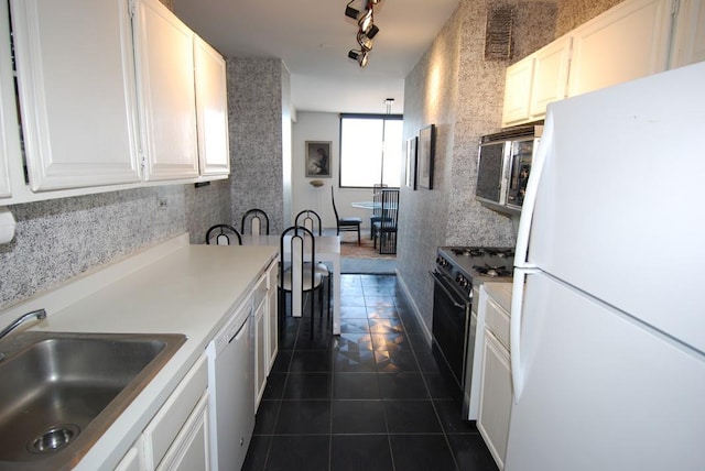 kitchen featuring dishwashing machine, sink, white cabinetry, white refrigerator, and gas stove