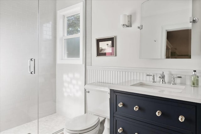 bathroom featuring vanity, a shower with shower door, and toilet