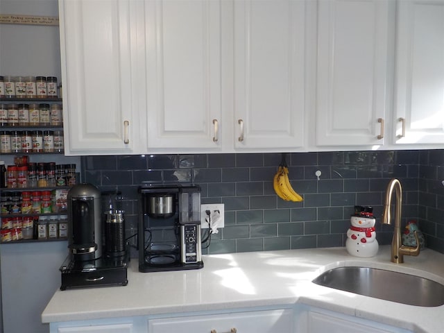 kitchen featuring sink, decorative backsplash, and white cabinets