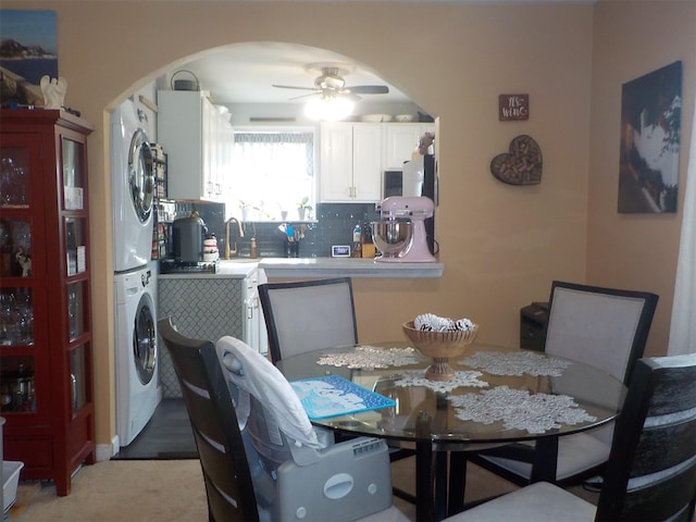 dining space featuring stacked washer and dryer and ceiling fan