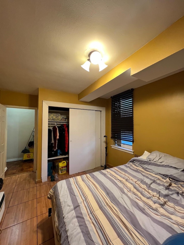 bedroom featuring hardwood / wood-style flooring, a textured ceiling, and a closet